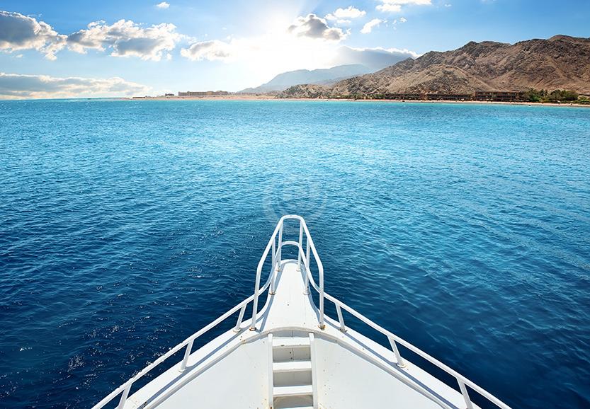 Front of a luxury white yacht on blue water
