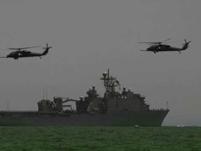 Naval ship at sea with two helicopters flying above